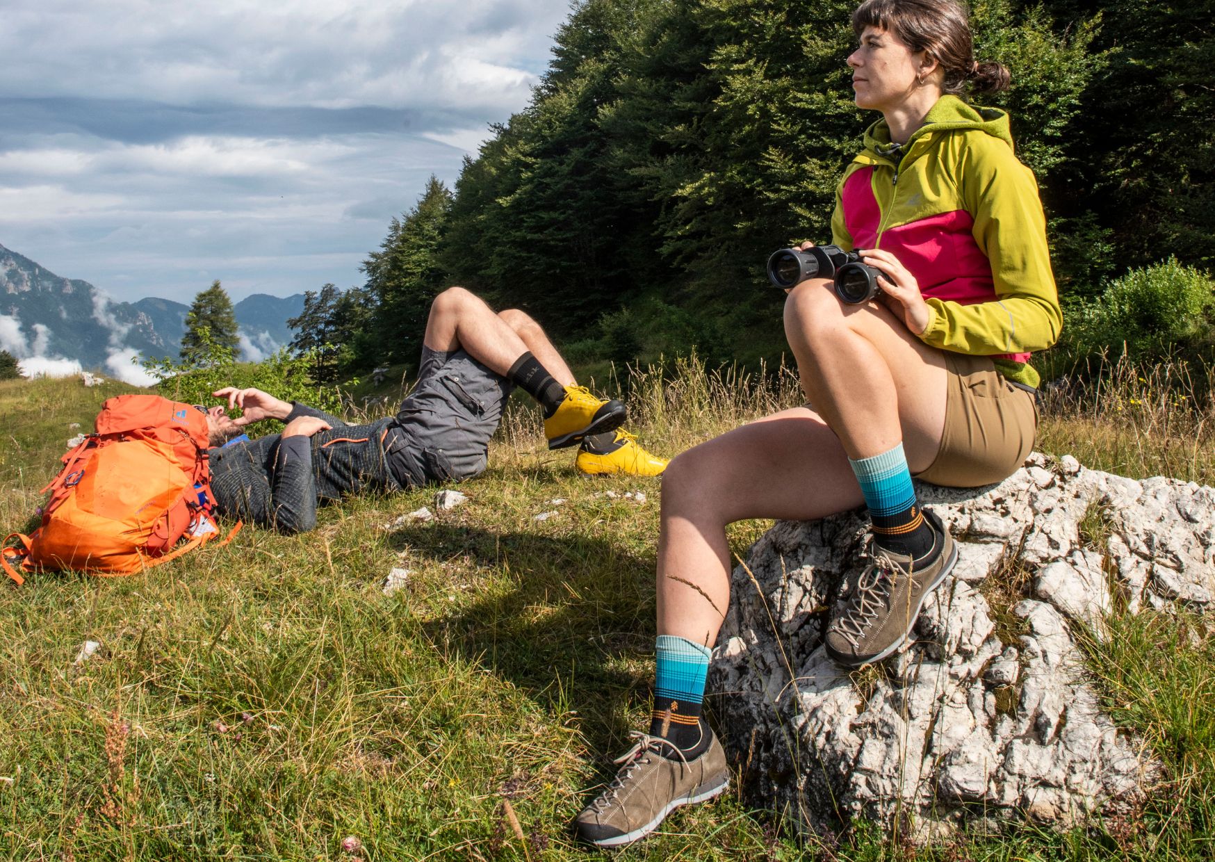 Trekking in primavera: escursionisti uomo e donna che si riposano sulla cima di una montagna indossando i loro scarponi Gronell