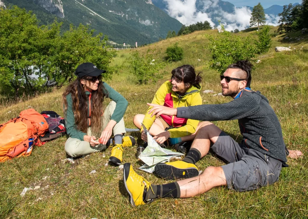 Gruppo di amici sulla cima di una montagna durante un'escursione con scarponi Gronell